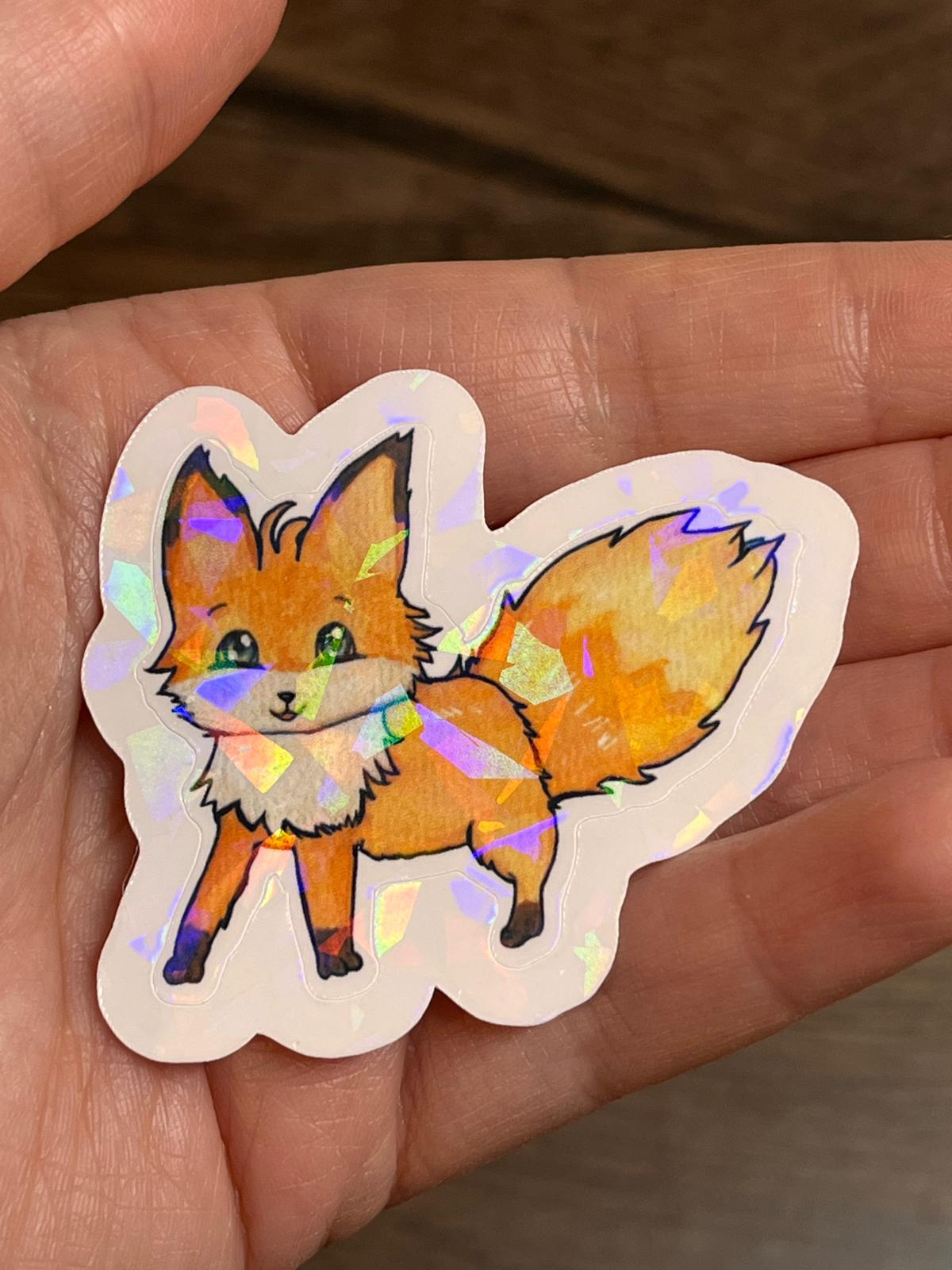 Glitzernder Sticker von Foxy in der Hand haltend