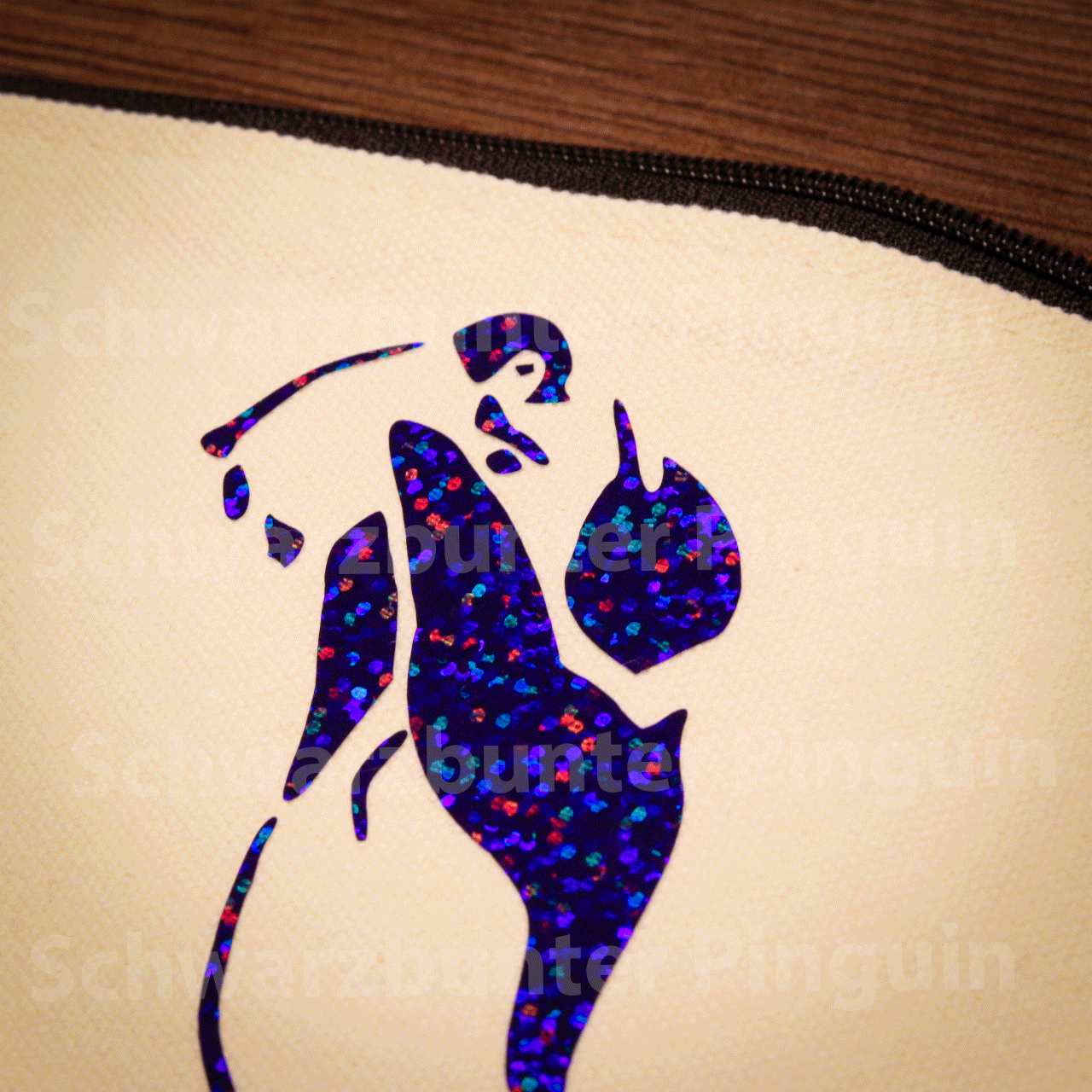 Detailansicht Mäppchen vom blau glitzerndern Schwarzbunter Pinguin Motiv, Tasche in beige mit schwarzem Zipper