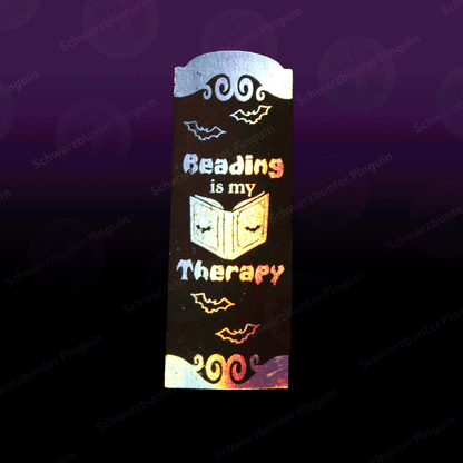 Lesezeichen mit Text "Reading is my therapy" in schwarz mit holografischer Folierung