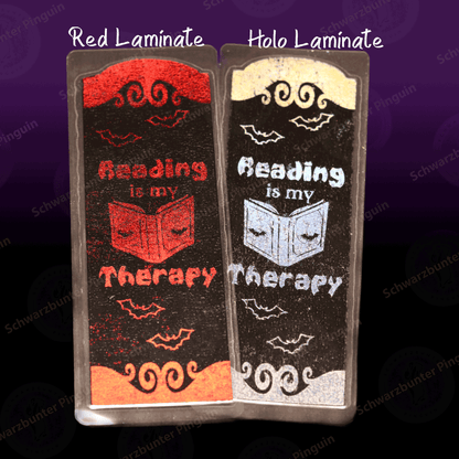 Lesezeichen mit Text "Reading is my therapy" in schwarz mit roter und holografischer Folierung sowie Laminat