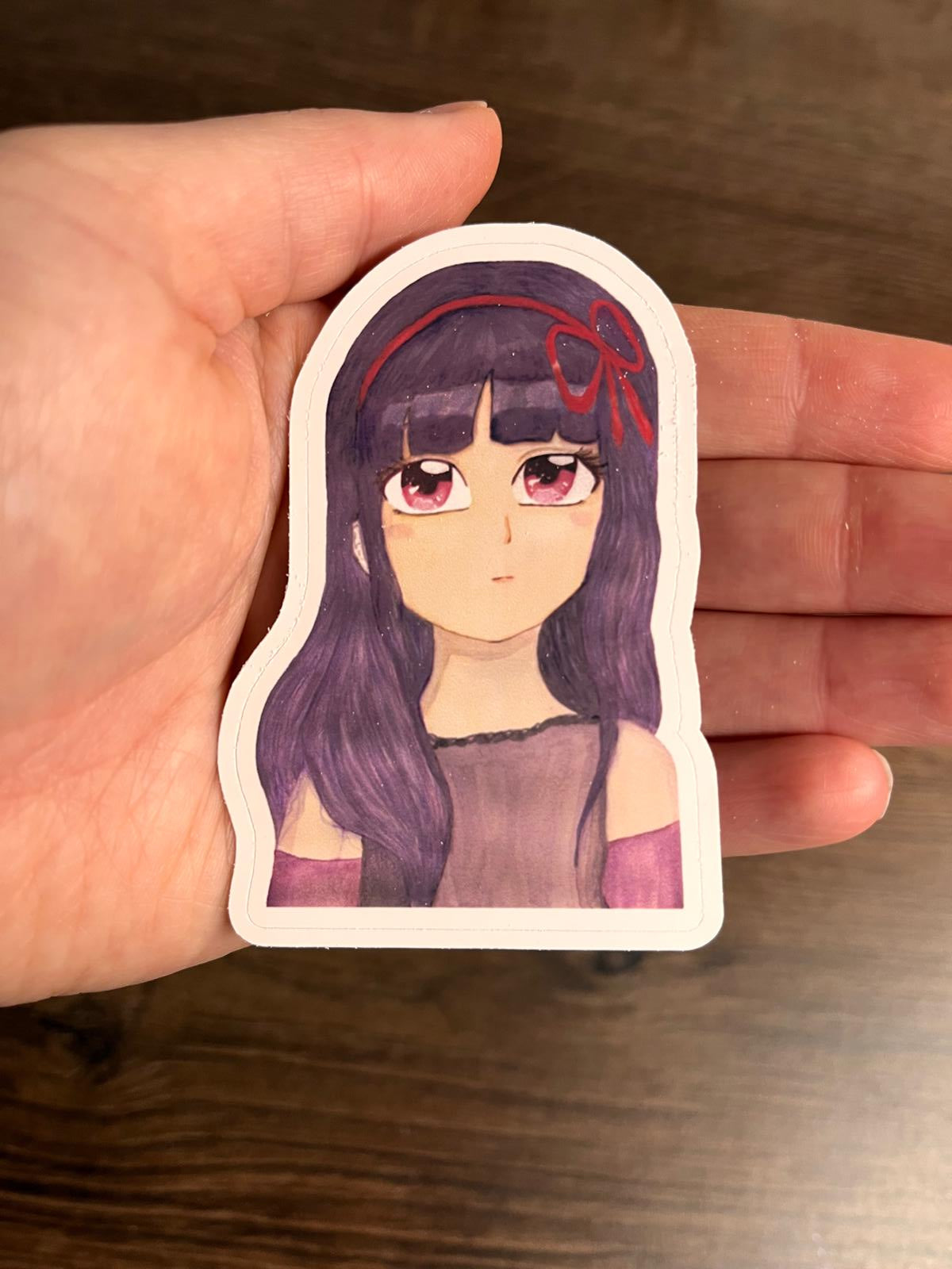 Matter Sticker "Lilith" in der Hand haltend