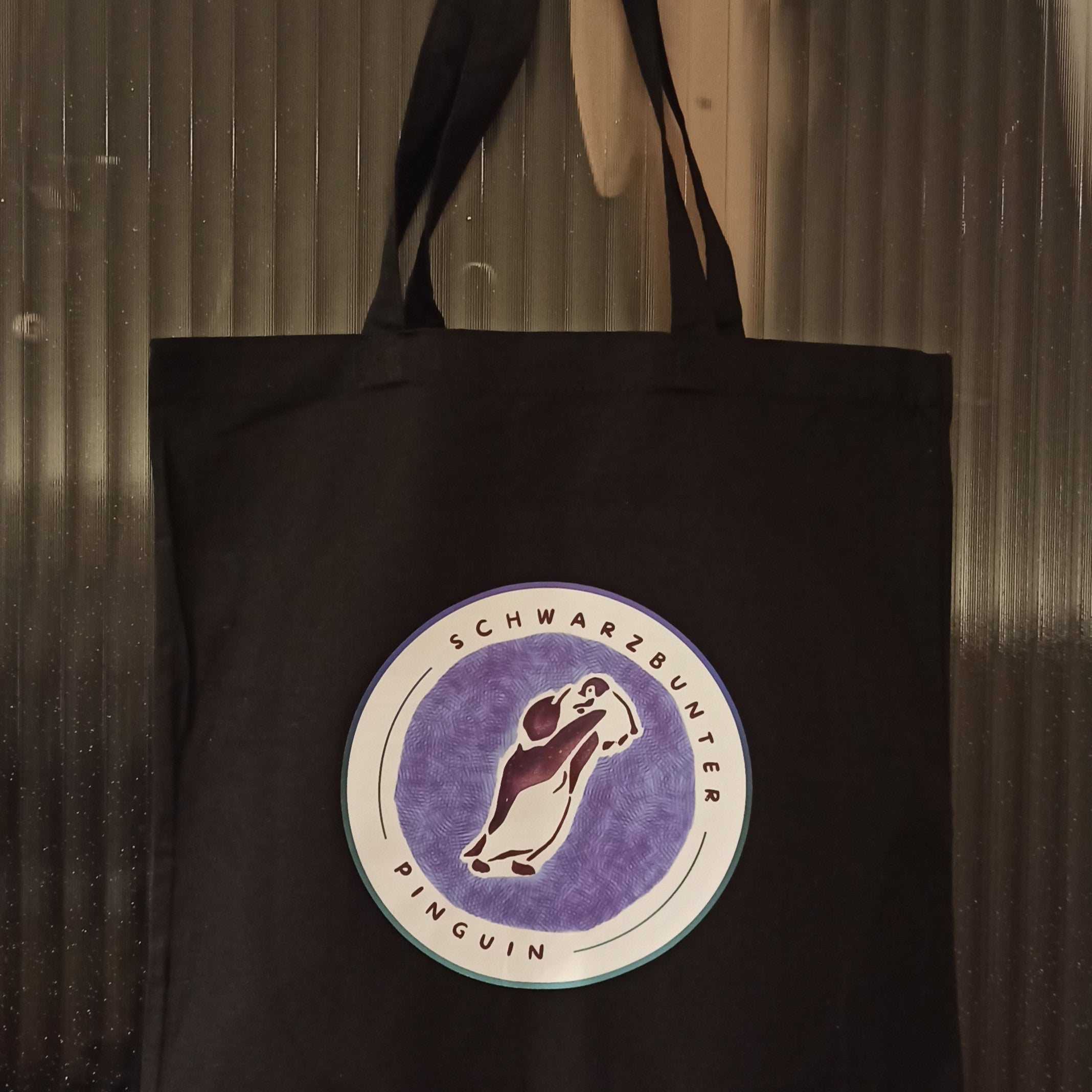 Schwarze Baumwolltasche mit Schwarzbunter Pinguin Logo