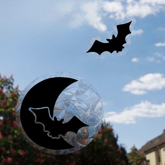Die Suncatcher "Fledermaus im Mondschein" und eine einzelne Fledermaus auf eine Fenster geklebt