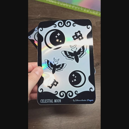 Video vom Holo Sticker Sheet mit 6 Stickern: Zwei Monde, zwei Motten und zwei funkelnde Sterne in schwarz.